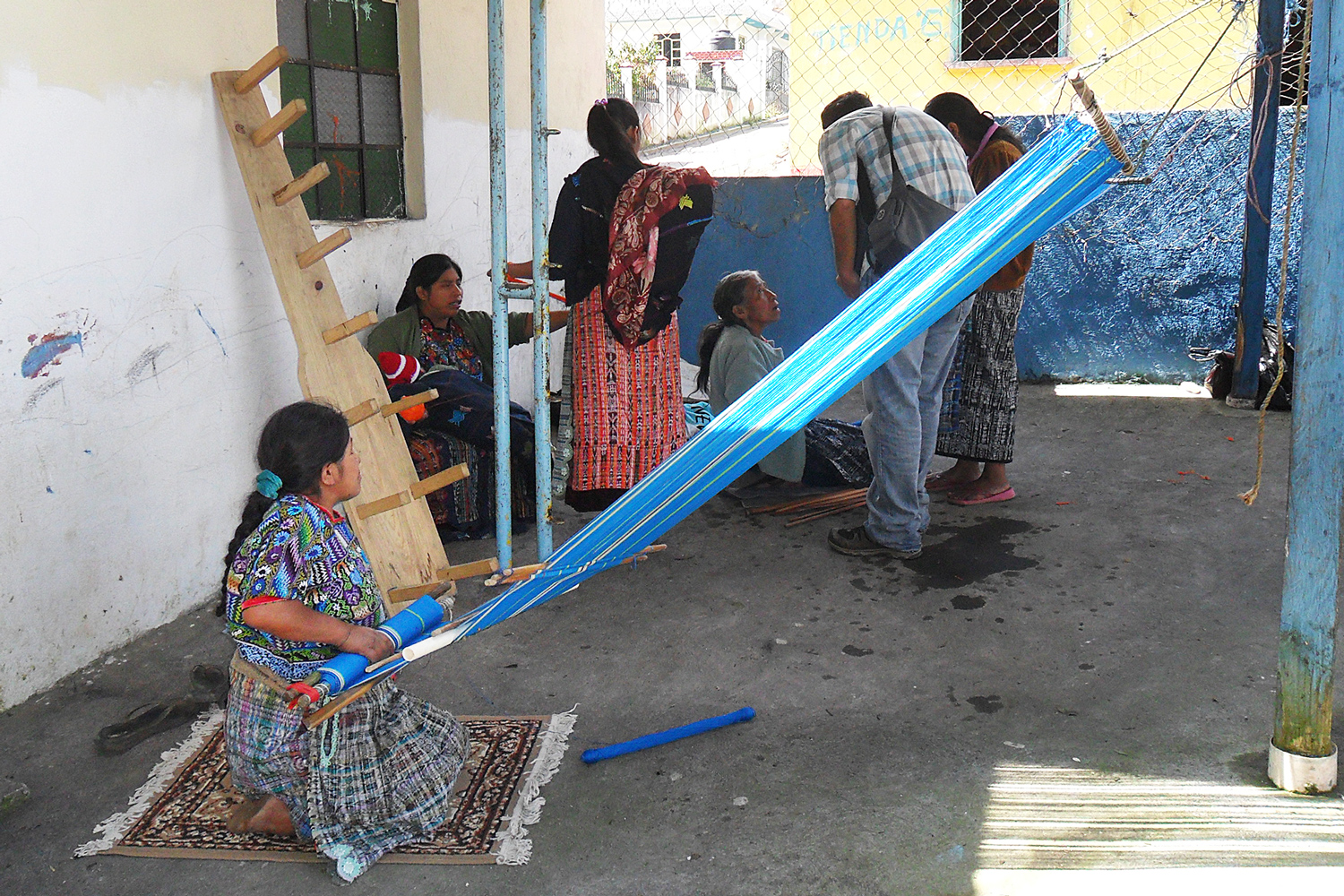Weavers preparing to produce the designs on the waist loom